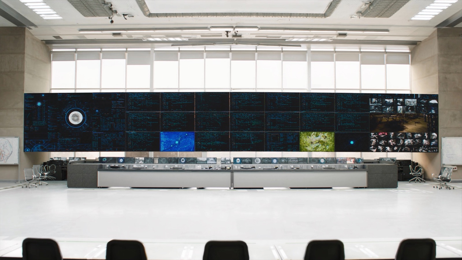 Satellite operations control room, consoles lit against a dark floor