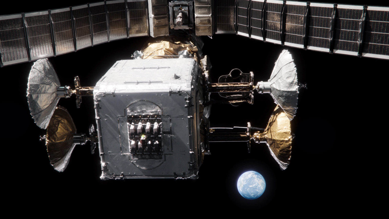 A geostationary communications satellite in sunlight, box-shaped bus with solar wings extended above and four deployable reflector dishes on its sides, a feed-horn cluster on the near face with a single chartreuse status light, and the small blue disc of Earth far below.