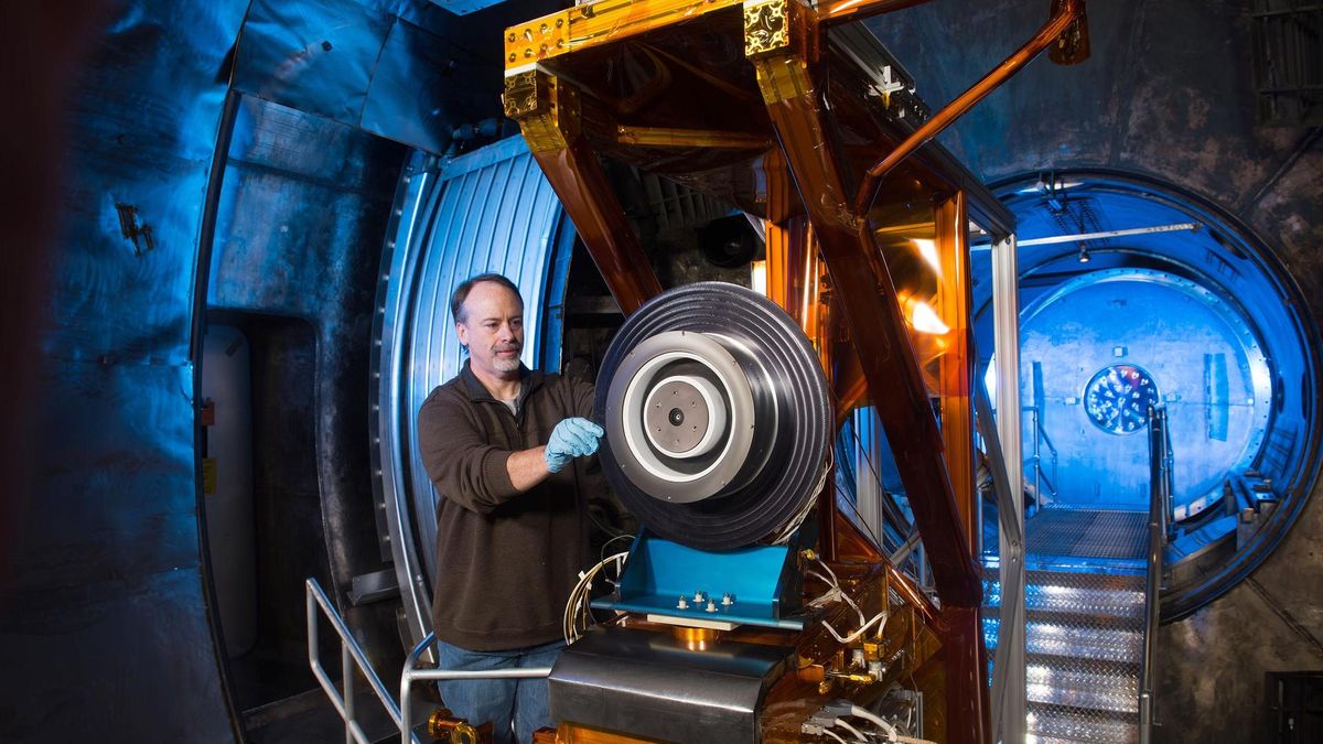 Engineer preparing a Hall-effect thruster for vacuum-chamber testing